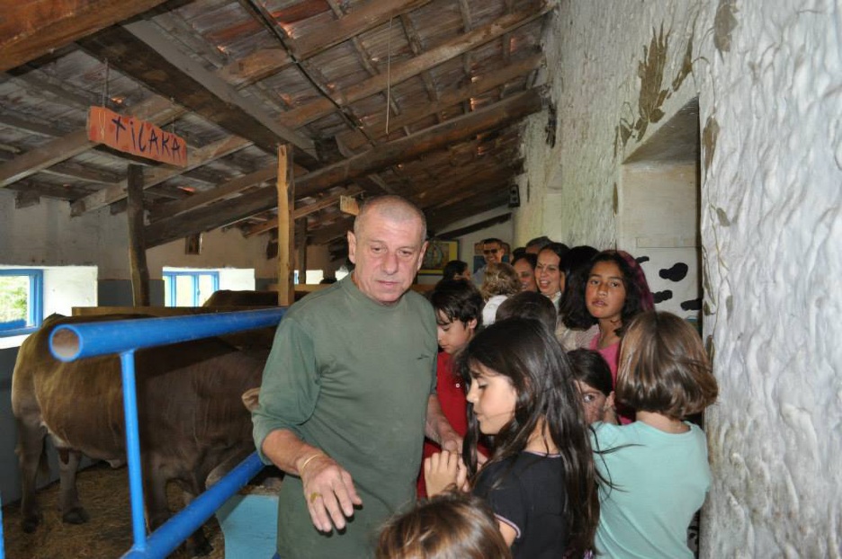 A person standing in a barn with kids
AI-generated content may be incorrect.